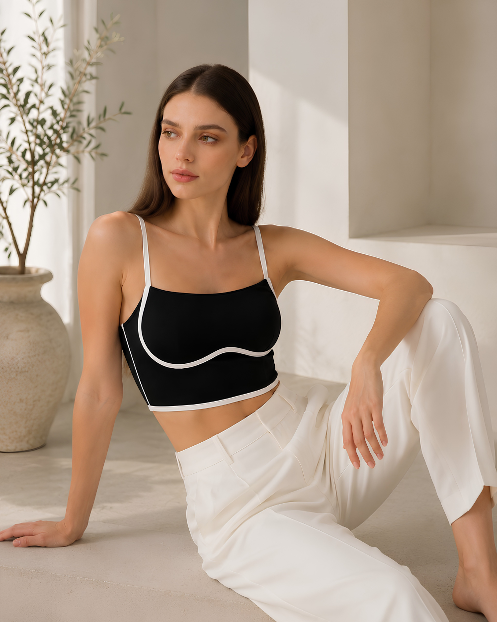 Luxury model wearing the Intyra Monochrome Muse Corset Top styled with black leather pants for a sleek modern fashion look.