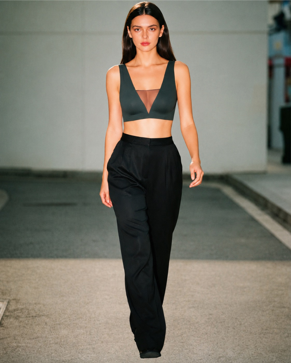 Model wearing the Intyra Onyx Allure Contour Top featuring a plunging V-neckline, sheer mesh detailing, and a sculpted black silhouette.