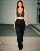 Model wearing the Intyra Onyx Allure Contour Top featuring a plunging V-neckline, sheer mesh detailing, and a sculpted black silhouette.