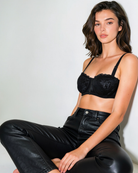 Model wearing the Intyra Midnight Allure Lace Bandeau styled with black leather pants for a bold luxury fashion look.