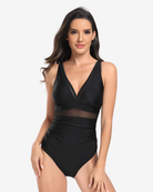 Midnight Mirage One-Piece swimsuit featuring a plunging neckline, sheer mesh detailing and sculpting ruched silhouette on a white background.