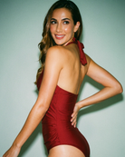 Back view of model wearing the Velvet Rouge Halter Swimsuit styled for sophisticated tropical resortwear.